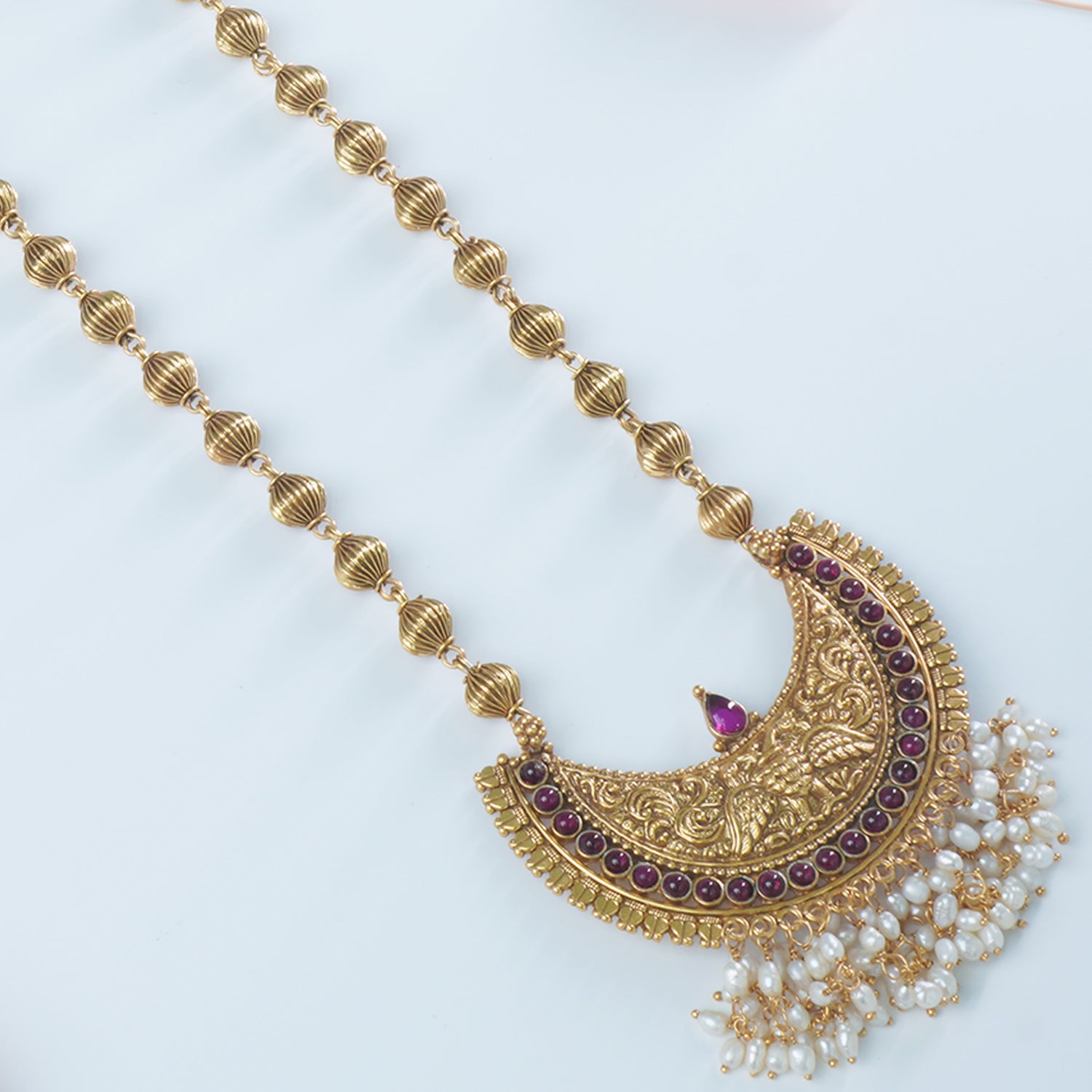 A closeup of gold plated silver pendant studded with freshwater pearls