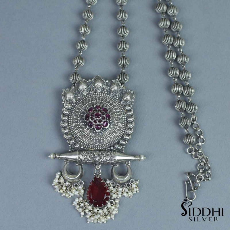 handmade tribal silver pendant with an red emra;d stone and chandrakor pieces