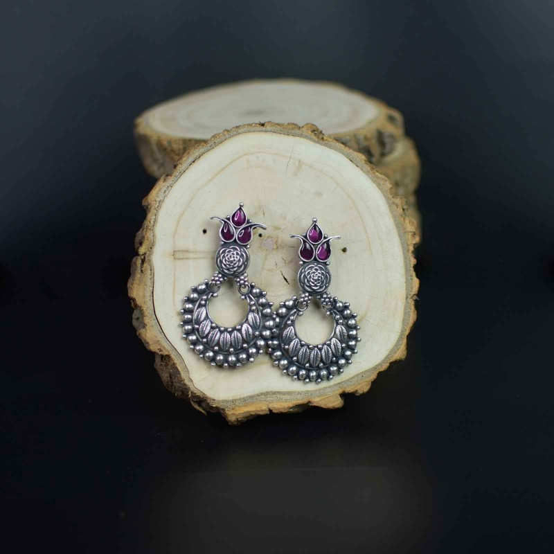 silver jhumka with red kemp stones.
