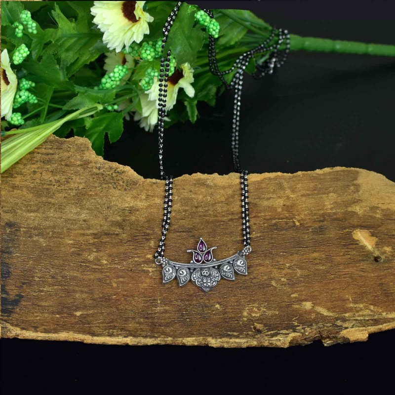 hand made silver mangaslutra design with kirthi mukh pendant studded with peacock pieces.