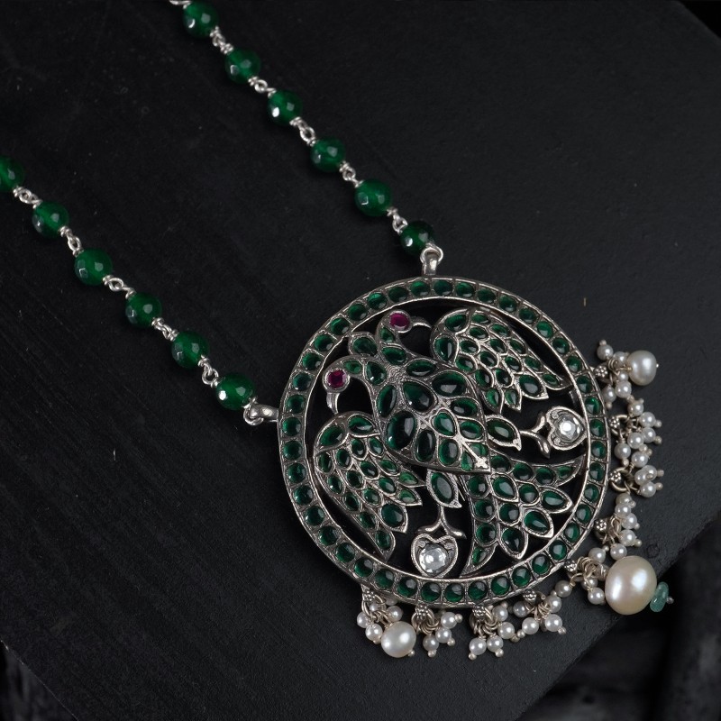 silver pendant with green stones