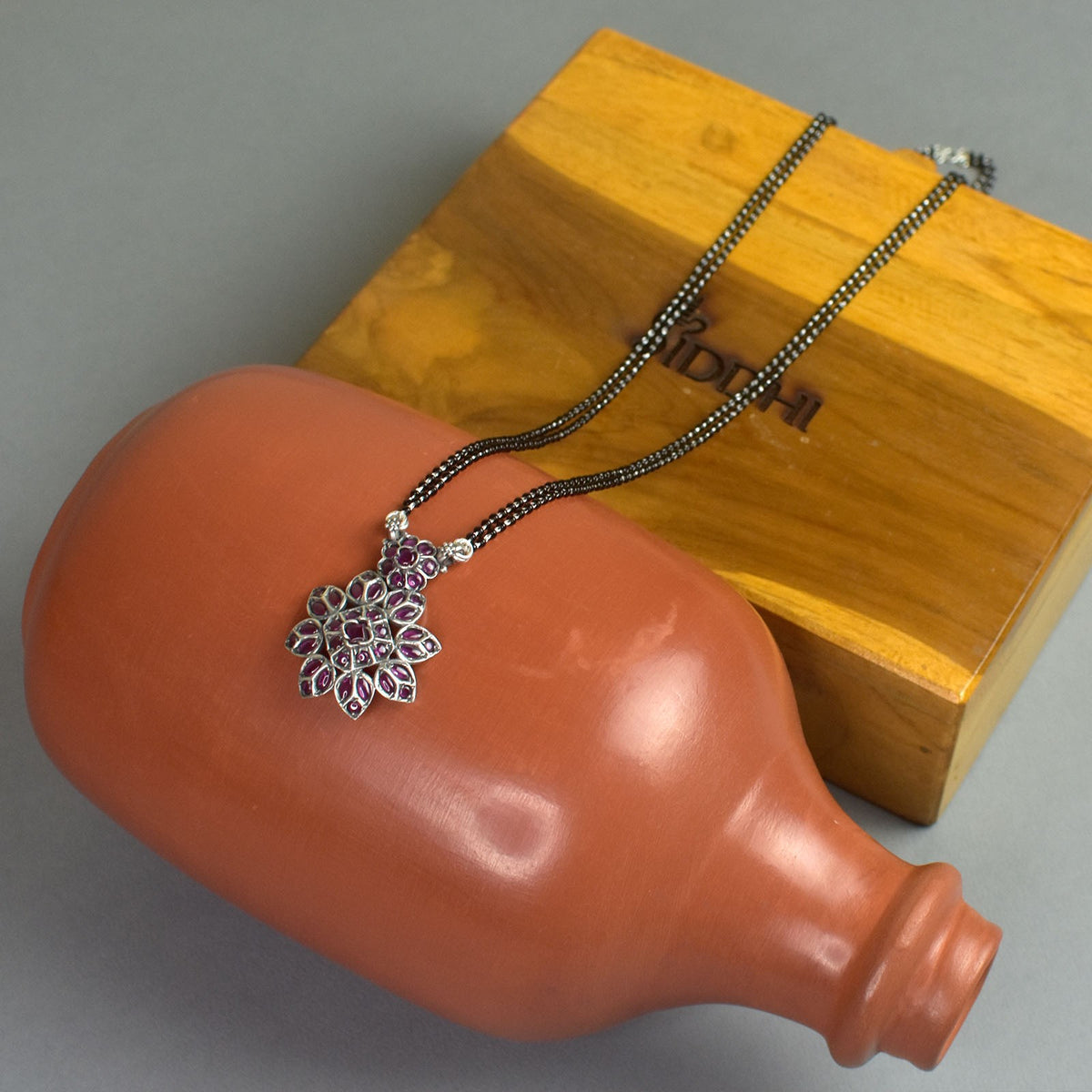 silver mangalsutra with a red kemp filled pendant