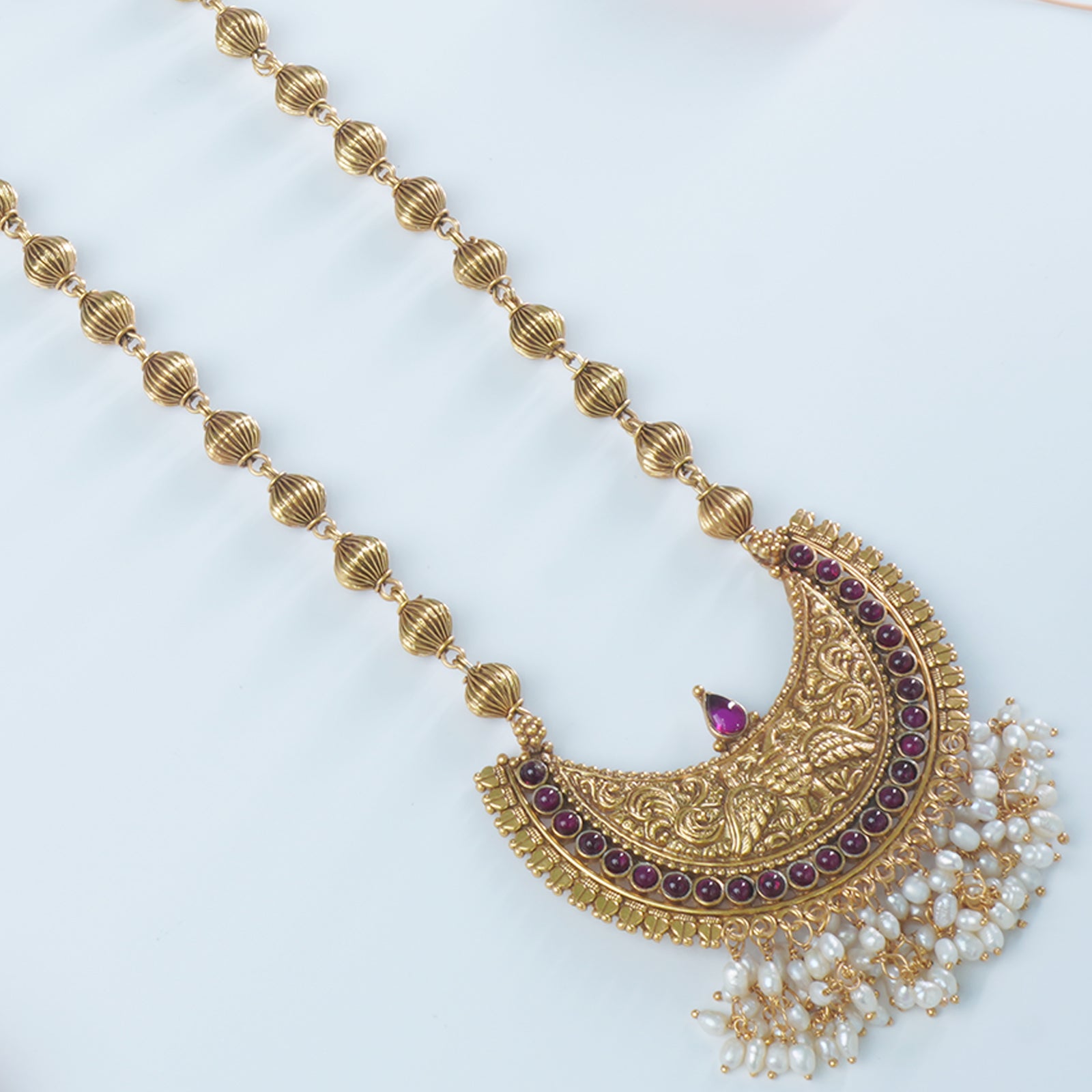 A closeup of gold plated silver pendant studded with freshwater pearls