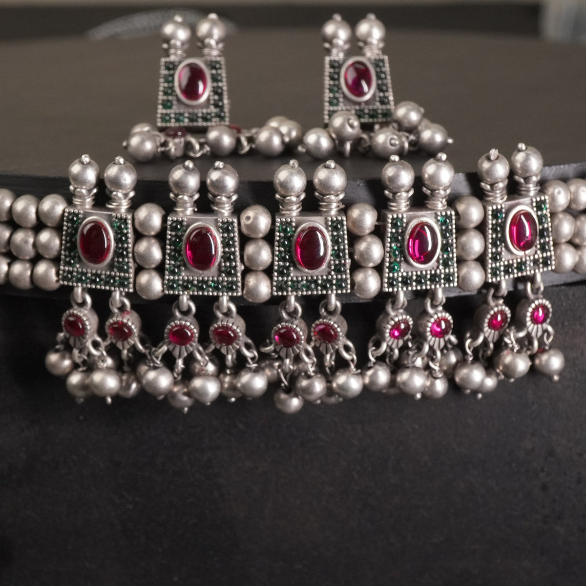 a closeup of silver chinchpeti necklace design with silver beads and matching silver beads earrings. 