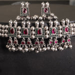 a closeup of silver chinchpeti necklace design with silver beads and matching silver beads earrings. 