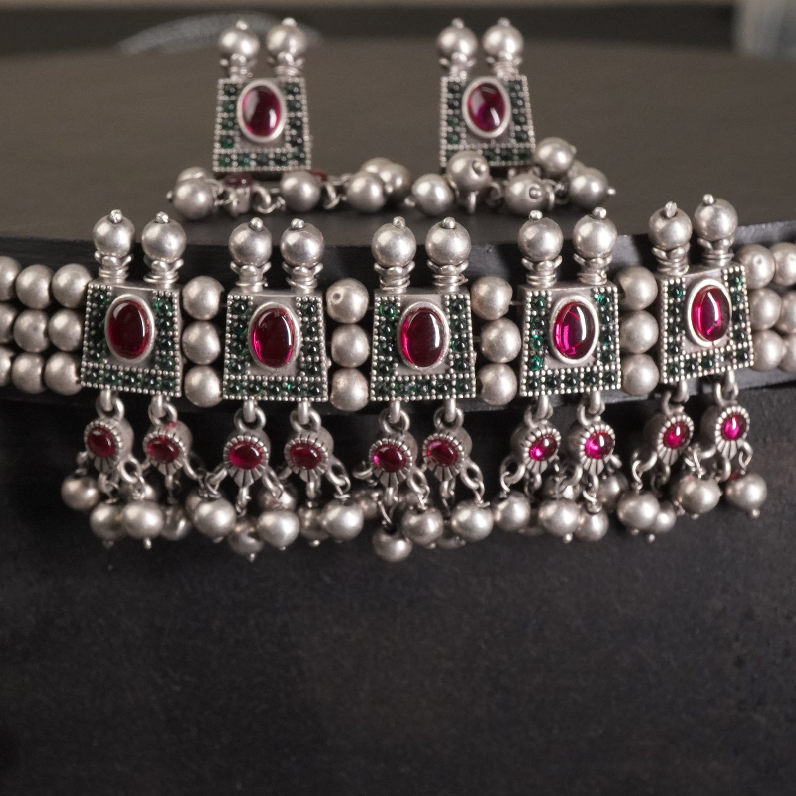 a closeup of silver chinchpeti necklace design with silver beads and matching silver beads earrings. 