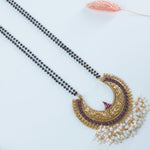 a close lookup of a silver mangalsutra with a kemp studded pendant