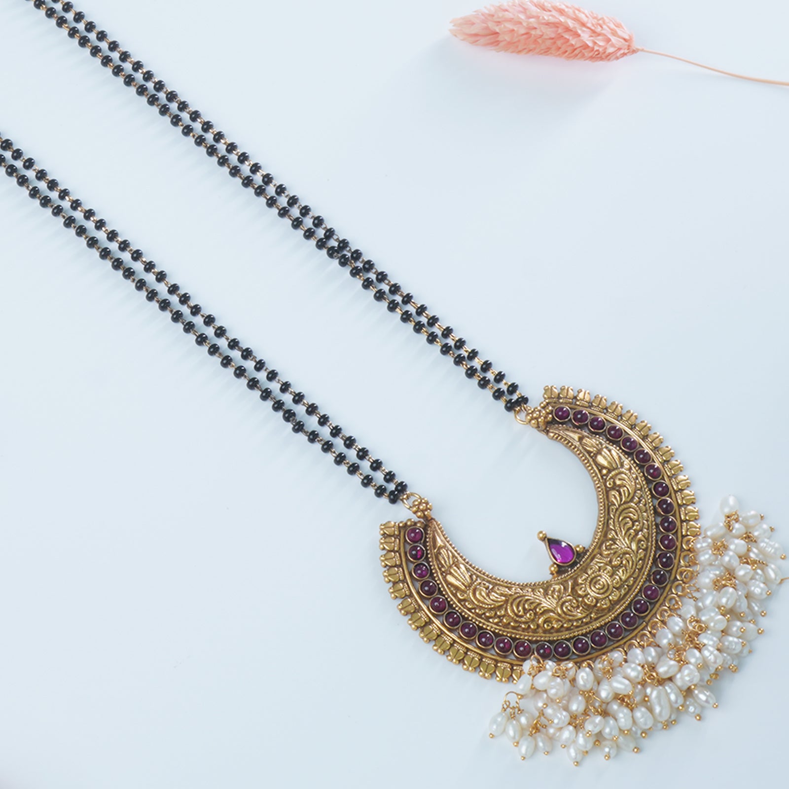 a close lookup of a silver mangalsutra with a kemp studded pendant