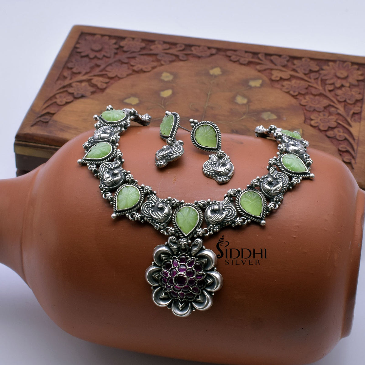 Trendy silver necklace with carved stones.