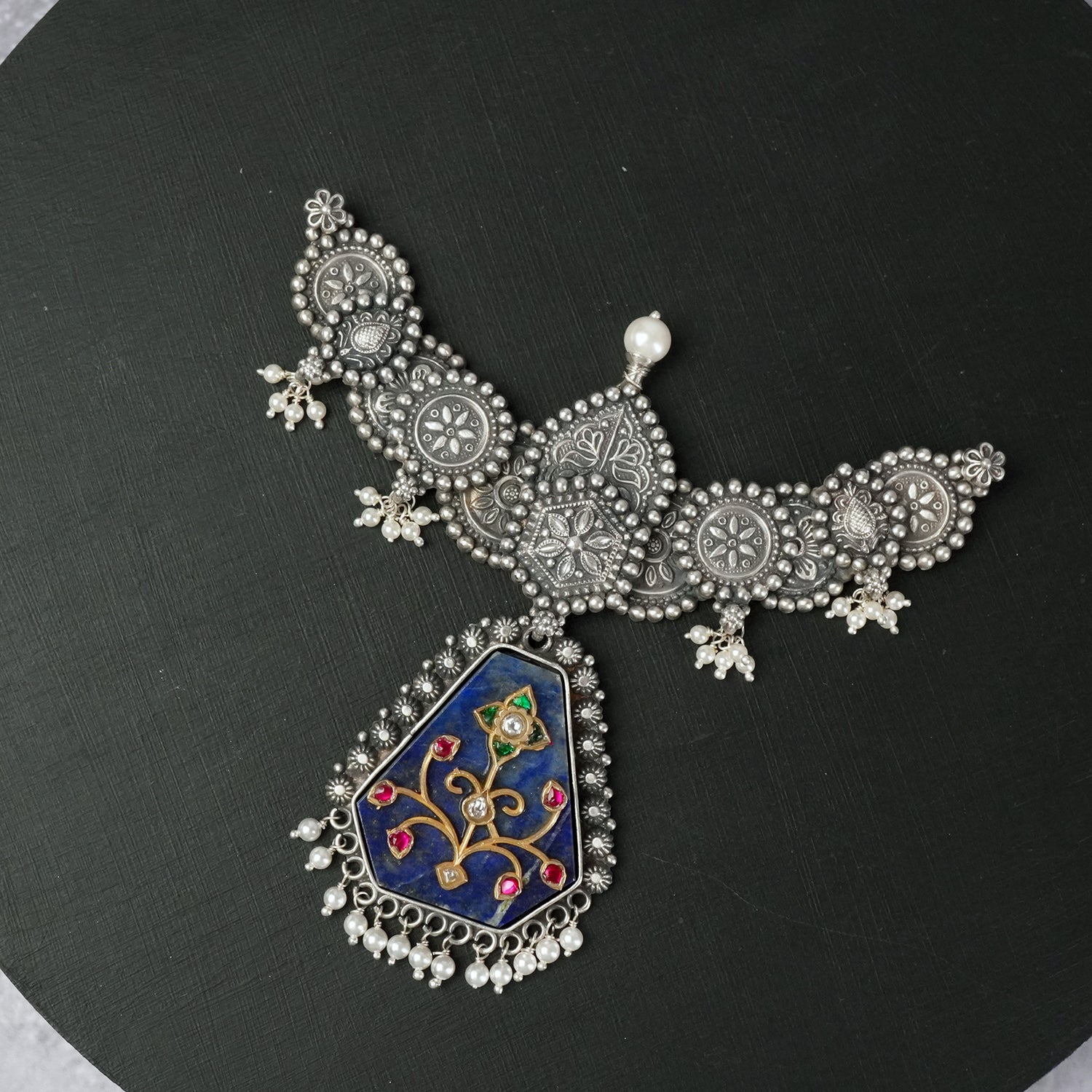 a handmade silver pendant with kundan filigree work