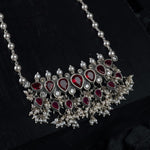 a silver tanmani pendant with red emrald stones and freshwater pearls.