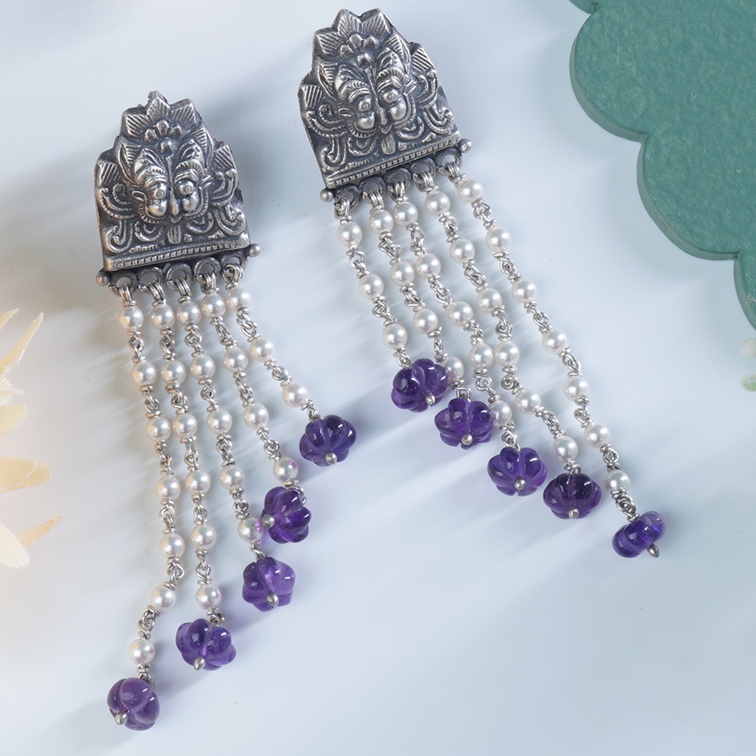 a closeup photo of silver pearls earrings with amethyst beads