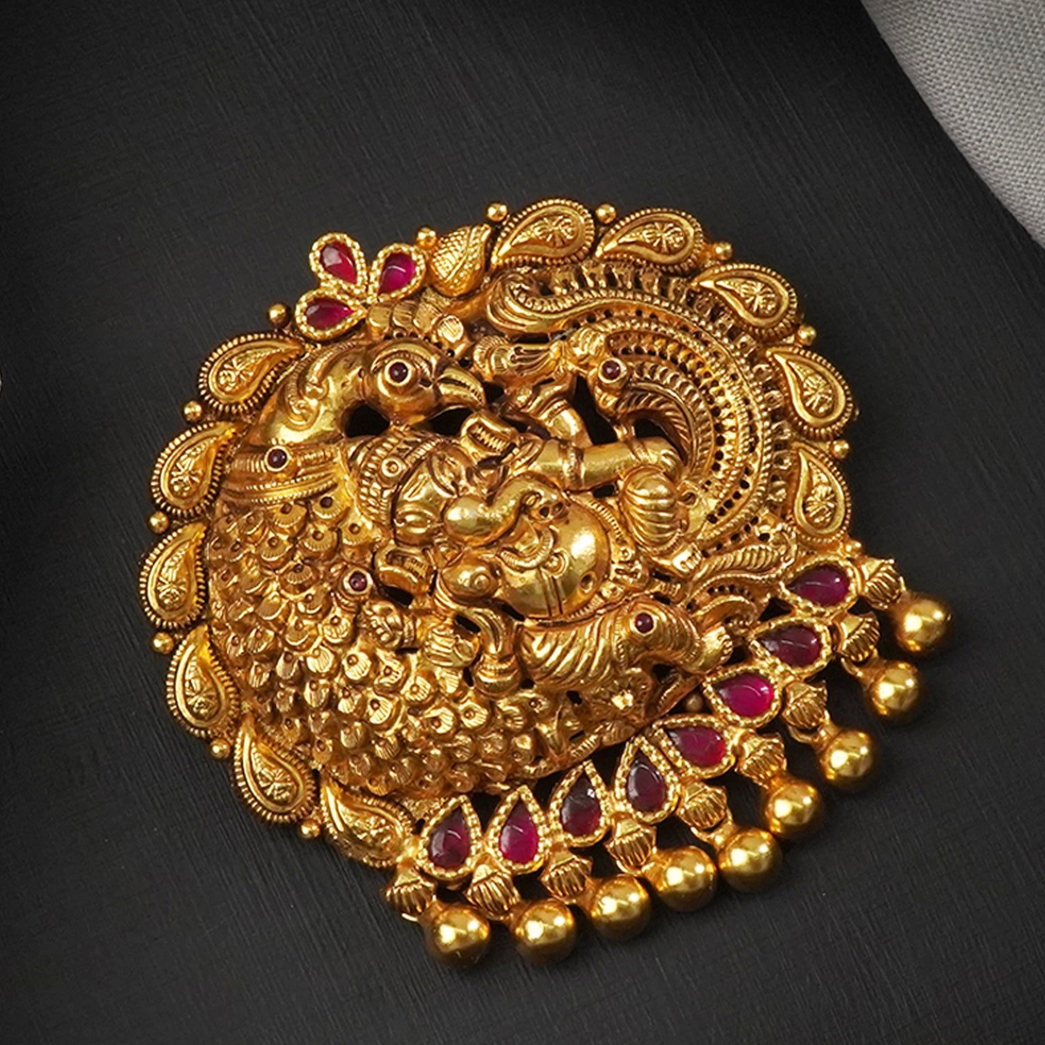 a gold plated silver pendant design with ganesha carving .