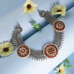 dual tone silver and red necklace on a light blue background with yellow flowers
